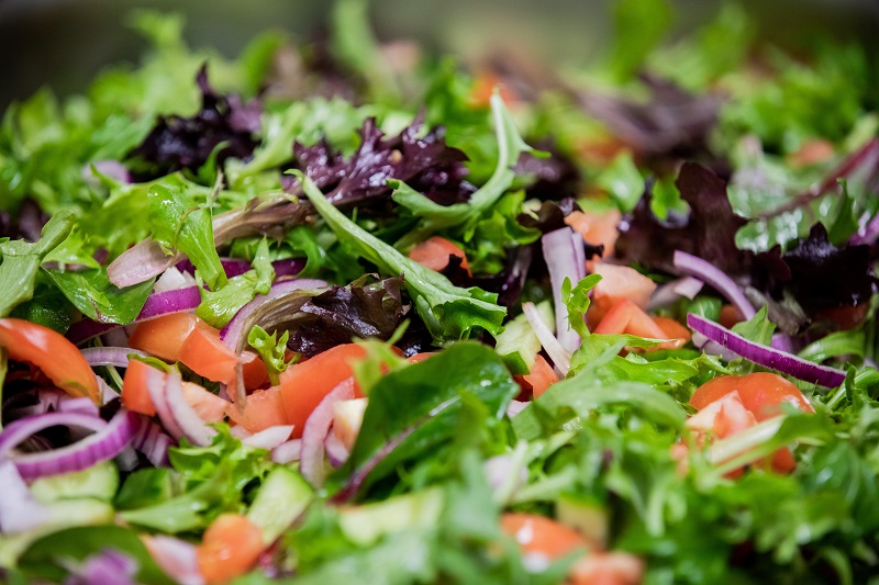 Fresh salad with green lettuce, red tomatoes, red onion