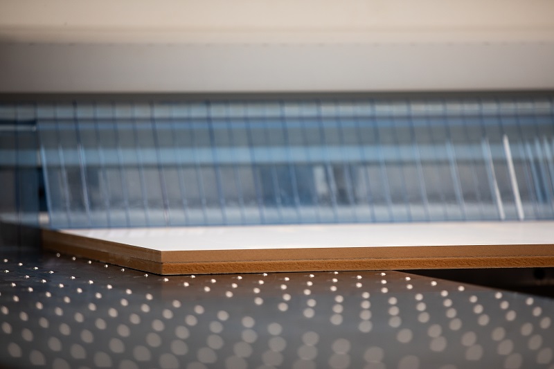 Wood being cut on flat bed machine