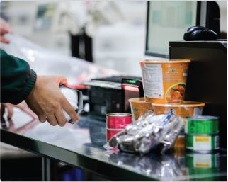 A man scanning packaged food items for billing.