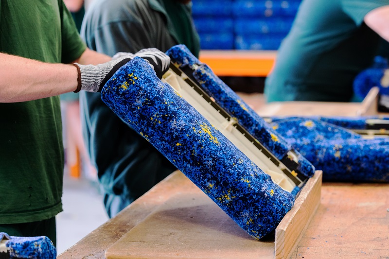 Person placing blue upholstery to a seat base