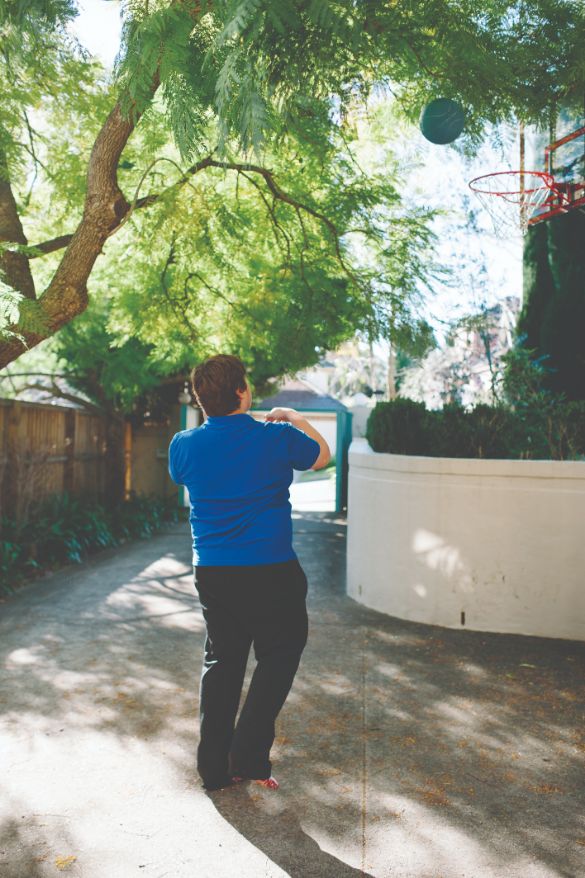 A young male walking out of a gate in a blue shirt