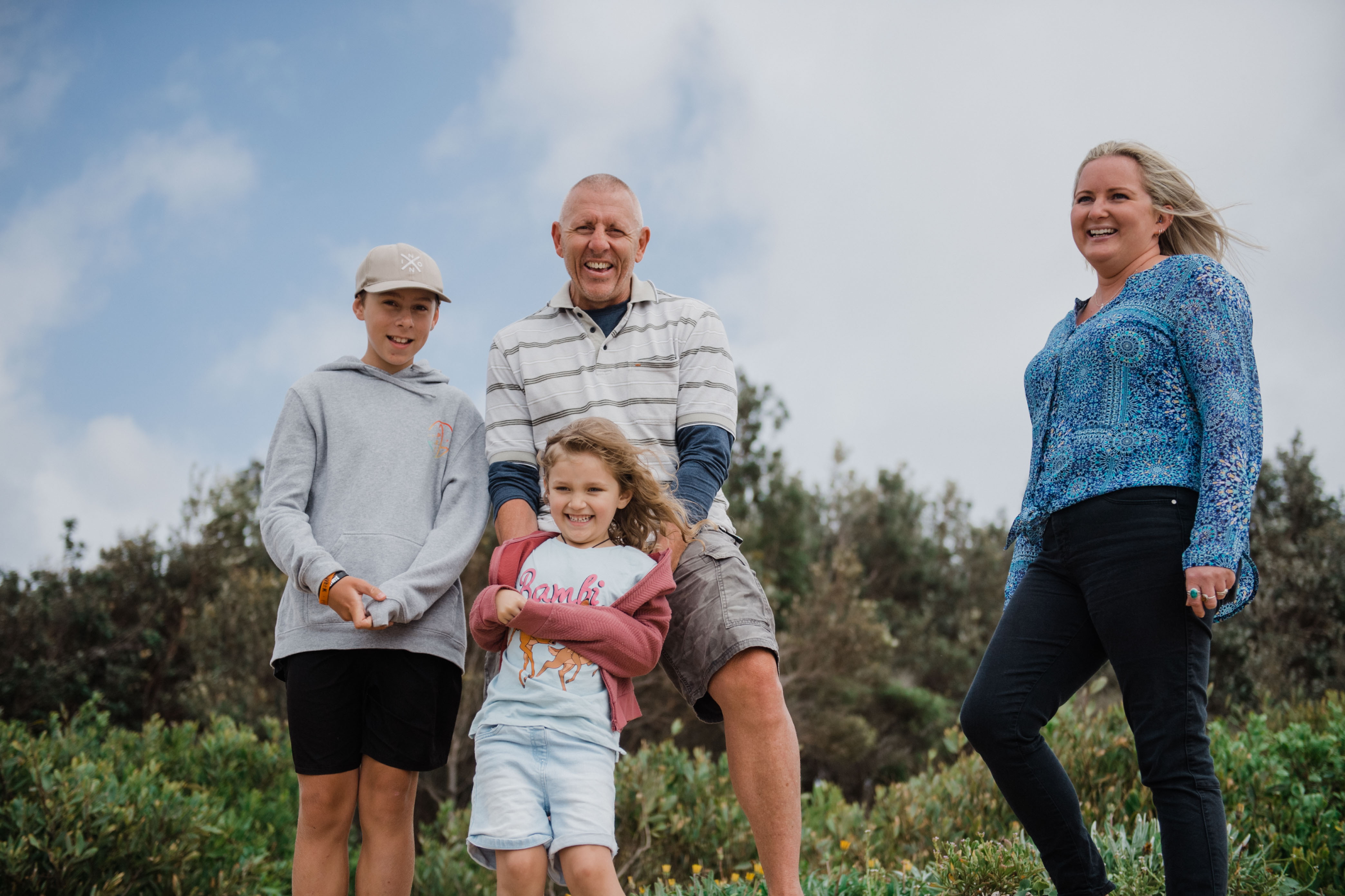 A picture of a man with his two children one young boy and one young girl looking happy. 