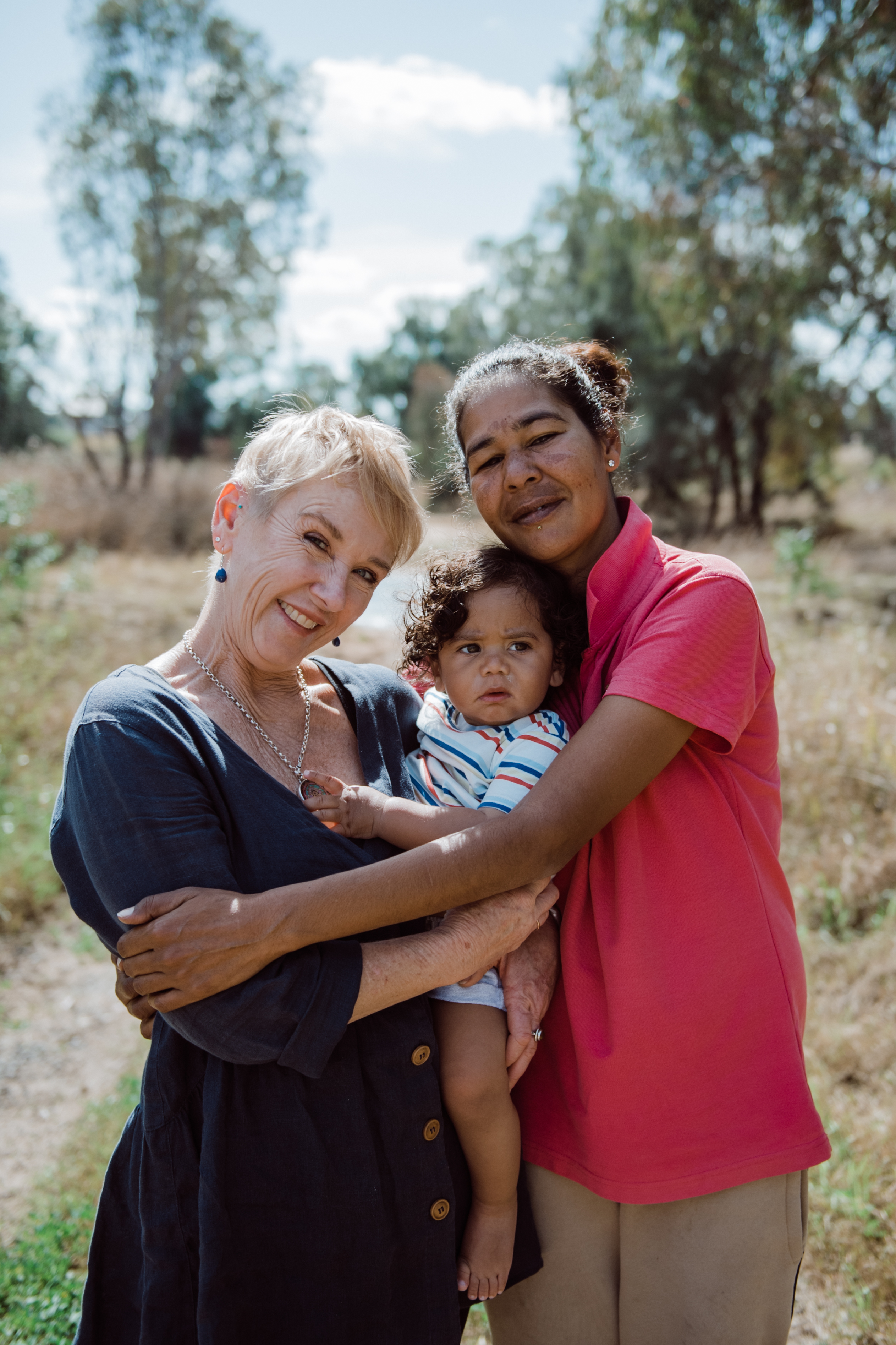 Photo of two adult female holding a baby