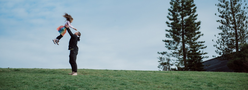 Photo of a man throwing a child in the air in the distance